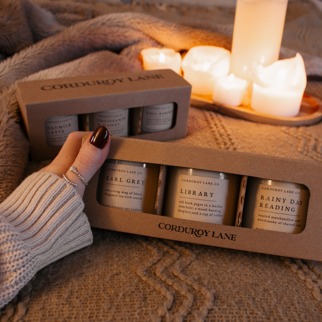 Corduroy Lane candle set with candles in the background on a soft surface