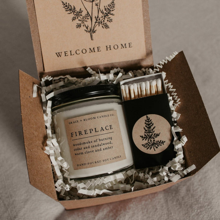 Candle set with 'Welcome Home' card in a box on a gray background