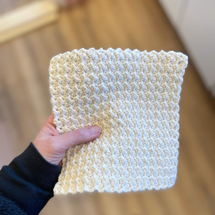 a hand holding a crocheted facial washcloth, 8"x8"